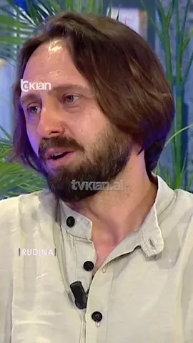 A post by @rtvklanofficial on TikTok caption: "Të ishte një moment i ngrohtë" pianisti zbulon dëshirën për koncertin e veçantë  Kishim në këtë pjesë një pianist, improvizues, kompozitor dhe poliinstrumentist, një figurë eklektike në skenën muzikore shqiptare dhe ndërkombëtare.  Ai është Robert Bisha dhe do të vijë në mbrëmjen e 14 qershorit në skenën e Teatrit të Operës dhe Baletit me një koncert të veçantë PAS 16 VITESH 𝐧ë 𝐩𝐢𝐚𝐧𝐨 𝐬𝐨𝐥𝐨 𝐦𝐞 𝐩𝐫𝐨𝐣𝐞𝐤𝐭𝐢𝐧 “𝐎𝐧 𝐭𝐡𝐞 𝐑𝐨𝐚𝐝”. Videon e plotë e gjeni në kanalin e YouTube ▶️ RTV KLAN #TvKlan #Rudina #Piano