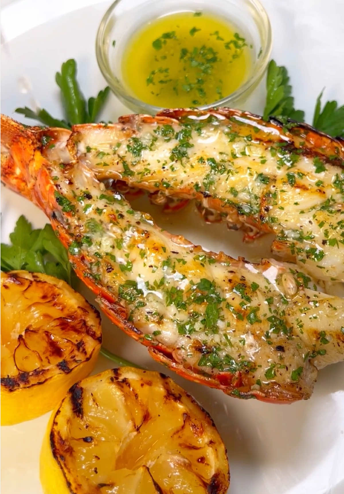 A post by @chefgenevieve on TikTok caption: Grilled lobster tails dripping in garlic butter and kissed by fire 🦞🔥🍋 This one’s for the seafood lovers, don’t skip the grilled lemons 😮‍💨 #GrilledLobster #SeafoodGoals #LobsterTails #GrillTok #ButterLover #ChefTok #SummerEats #TikTokFoodie
