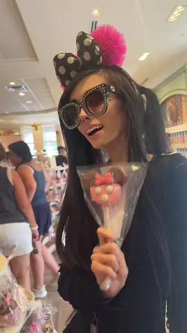 A post by @eugeniaxo on TikTok caption: Wandering into the sweetest corner of Magic Kingdom 🍭✨ Minnie marshmallows, pink bows, and Disney dreams… what’s your favorite Disney treat? 🖤🎀 #disney #disneyworld #DisneyMagic #DisneySnacks #disneytreats #minniemouse #treatyourself #magickingdom #mainstreetusa 