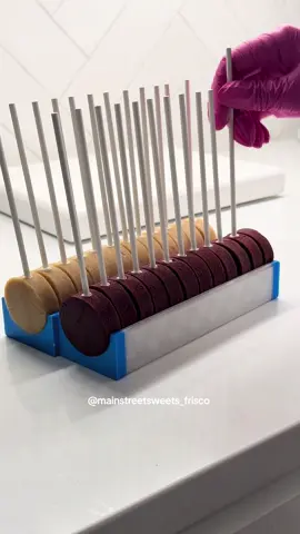 A post by @mainstreetsweets_frisco on TikTok caption: Replying to @Anna🍉 here’s a visual + a few tips: 1. make sure your dough is rolled out to at least 1/2 inch depth—any thinner and you’ll be able to see your sticks 2. if your dough is cracking when inserting your sticks, your dough is too dry, or your pops are too thin! try baking for less time or adding a little bit of frosting to bind it together.  3. make sure your cake pops are lined up straight, if they’re even slightly slanted, you’ll pierce right through the side of your pop 4. I insert my sticks all the way down until they hit the tray (didn’t used to, but this allows for exact consistency of height per pop!) 5. make sure if you purchase this @Daisy Makes tray, you use the code MAINSTREET10 to save some money! 🥰 I’m using the large here