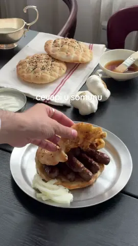 A post by @ivo_zinee on TikTok caption: Domaći ćevapi i somuni, uz jedan dobar sevdah. (Recept u opisu!) A koliko su ćevapi klasik na našim prostorima, toliko je i Gorenje klasik uz tradiciju od 75 godina. / Ad - Werbung RECEPT: Ćevapi: 1kg mesa (500g junetine i 500g teletine) 100 ml vode 4 režnja češnjaka 20g soli (ili više, po ukusu) mljeveni papar Somuni: 1000g glatkog brašna 14g suhog kvasca 250ml mlijeka 450ml vode 1 žlica šećera 2 žličice soli crni sezam POSTUPAK: Očistiti češnjak i prokuhati u vodi. Ohladiti, a potom preliti meso i ostaviti nekoliko sati u hladnjaku. Zatim meso samljeti 2 puta na sitno, a potom začiniti. U Gorenje stolnom mikseru mijesiti dok se smjesa ne ujednači (barem 15 minuta), a potom oblikovati kuglice teške 30g te prekriti folijom i ostaviti u hladnjaku nekoliko sati ili preko noći. Ćevape oblikovati tako da na vrećicu za zamrzavanje stavite kuglicu mesa, preklopite i pritisnete špatulom. Na taj način dobit ćete savršene i ujednačene ćevape. Peći ih na grillu, s malo ulja. Ja sam koristio Gorenje električni grill koji, osim što ravnomjerno peče, lako se i se čisti.  Za somune treba sjediniti sve sastojke i umijesiti ih u stolnom mikseru u glatko tijesto. Pustiti da se udupla, a potom ponovno premijesiti i ostaviti da se diže. Podijeliti na lopte, veličine po želji (moje su otprilike 100g svaka). Potom ih rukama rastanjiti, urezati uzorak štapićem ili obrnutom stranom noža, a potom pošpricati vodom i posuti crnim sezamom. Pustiti da odstoje na sobnoj temperaturi nekih 15 minuta i peći 5-8 minuta u pećnici ugrijanoj na maksimalnoj temperaturi u kojoj ste prethodno ugrijali pleh.  Kad se somuni napušu i dobiju lijepu boju, gotovi su.  Natopiti ih u junećoj juhi, staviti na ćevape na grilu, pustiti da se somun malo zapeče, a potom poslužiti s lukom.  #kuhanje #recept #Recipe #ćevapi #cevapi #somun #bosna #hrvatska #berlin #cooking #balkantiktok #silvanaarmenulic #Gorenje #LifeSimplified #Gorenje75