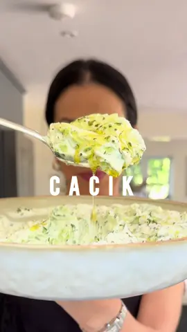 A post by @melizcooks on TikTok caption: Meliz Cooks Good Food: Episode 4, Cacık 🤍🥒🧄🍋🌿  A staple in my house growing up, it’s now, unsurprisingly, a staple in my own family home 🫶🏼 My recipe takes a well-known yoghurt and cucumber dip and turns it into something truly memorable. Straining the yogurt results in a more indulgent texture and prevents the cacık from turning watery. Dip into it with hot bread, serve with kebabs and meatballs, or simply eat it straight from the bowl with a spoon! It stores well in the fridge, covered, for up to four days. I’ve popped a few of my top tips below.  1. Strain the yoghurt overnight for a thick and luscious creamy base (use the strained yoghurt water, the “acid whey” in place of water / milk when making bread - SO GOOD for flavour and texture)  2. Remove the seeds from the cucumber (small Middle Eastern cucumbers are best as they are less watery than English cucumbers, sweeter and more flavoursome), grate and strain through a muslin cloth - use the seeds and strained juice for smoothies. So good for your skin!  3. Soak the dried mint in the lemon juice and olive oil to soften them first - you can use fresh mint but sweeter spearmint (like the soft, almost basil like leaves you find in cyprus) or Moroccan mint is best it you want to use fresh in place of dried.  * 500g thick natural yogurt * 2 tsp  lemon juice * 1 tbsp  extra virgin olive oil * 1 tbsp  dried mintplus extra to garnish * 1  English cucumber 2-3 x Middle Eastern cucumbers (approx 400g)  * 2 garlic cloves * A really good pinch of sea salt  Full recipe on the @GoodFood website. Link in bio.  Please make it!  #melizcooks #cacık #yoghurt #cucumber #meze #mezze #easyrecipe #recipe #pleasemakeit #meze #summerfood #summer #bbq #melizcooks