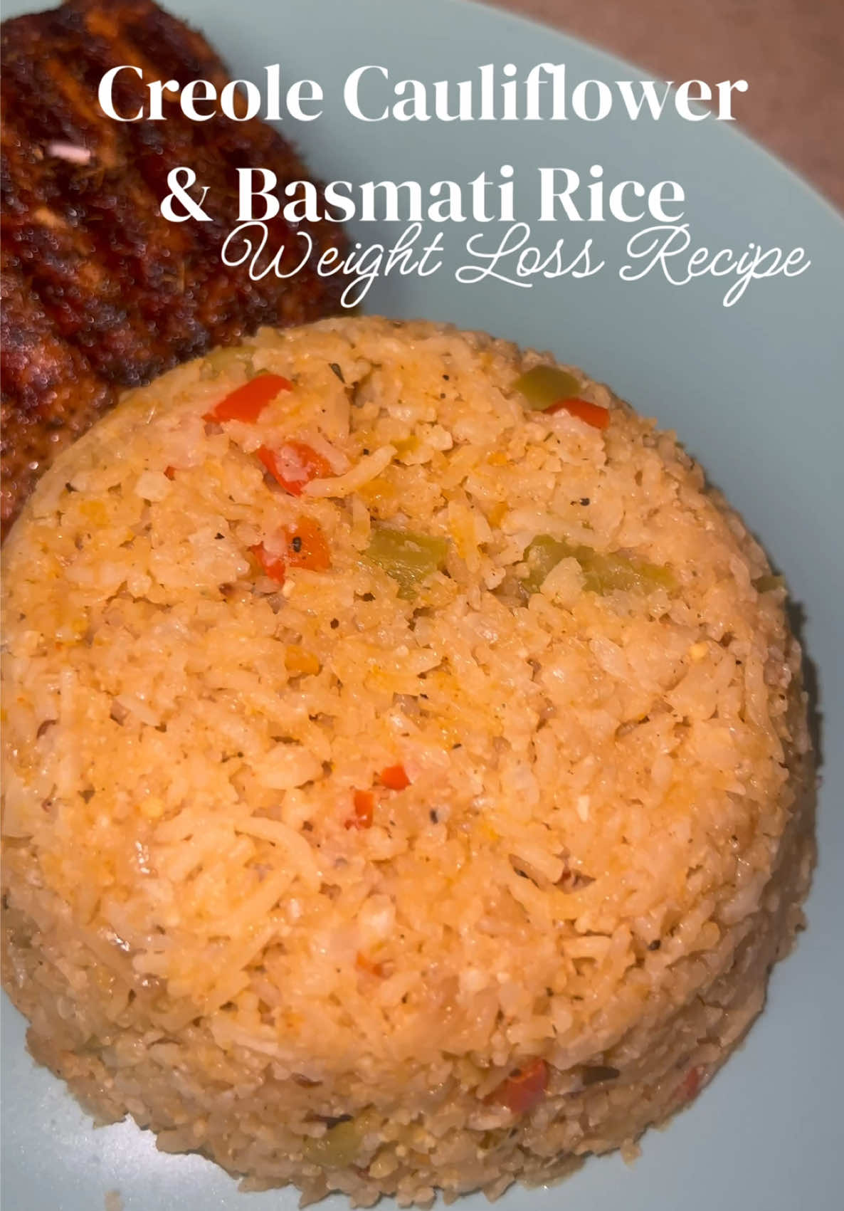 A post by @mishlovee on TikTok caption: Ingredients:  -2 cups Cauliflower -1 cup Basmati Rice  -2 1/4 chicken broth ( add more if needed )  -Green pepper -Red pepper  -White onion  -Butter & Olive oil -1 tablespoon of garlic -Seasoning: Garlic powder, onion powder, salt, pepper, garlic and herb, creole and smoked paprika.  Enjoy 🥂 Find more recipes in My Weight Loss CookBook 📚 Www.bodybymish.com