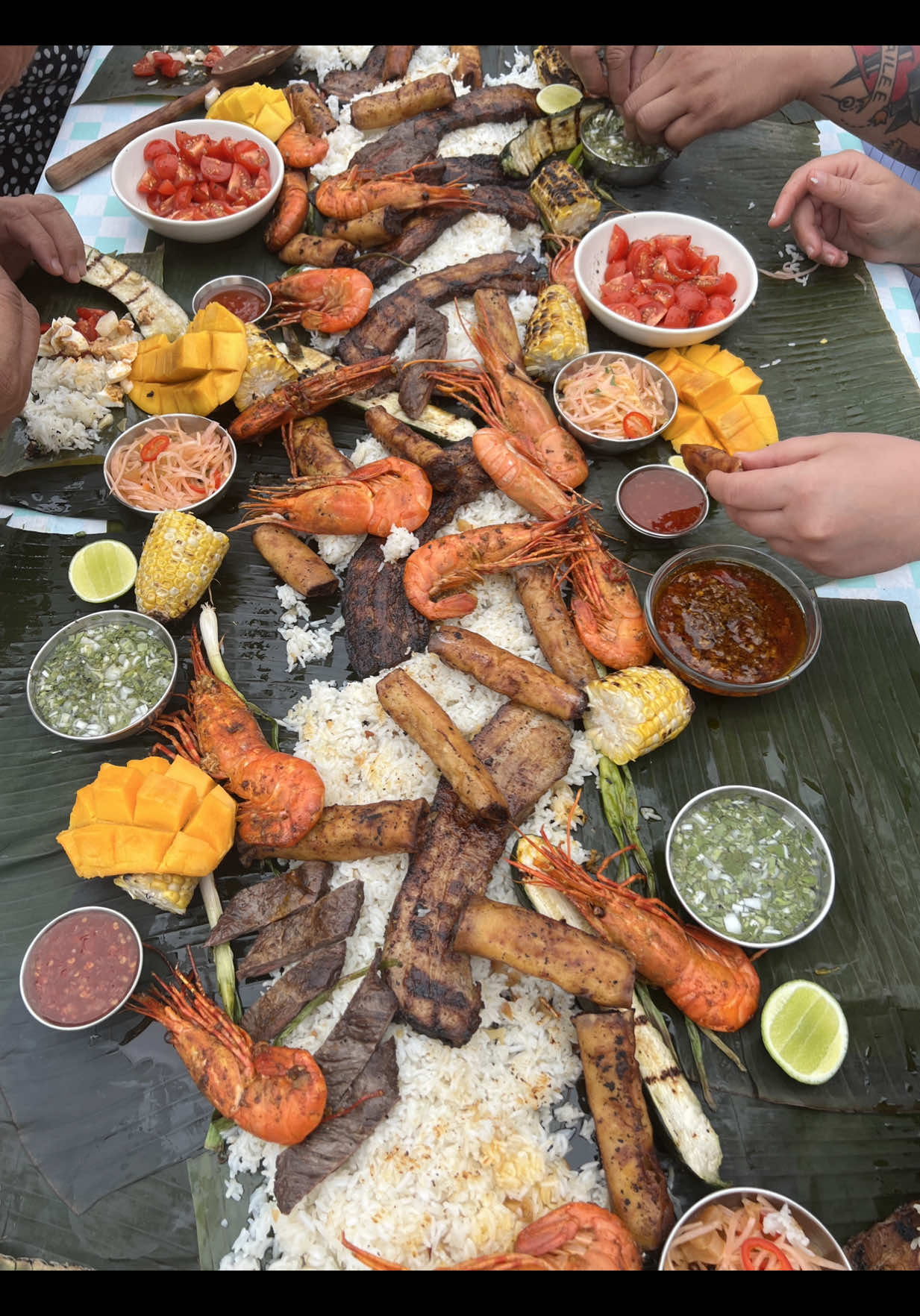 A post by @chuckischarles on TikTok caption: filipino kamayan feast with my @YETI cast iron pans