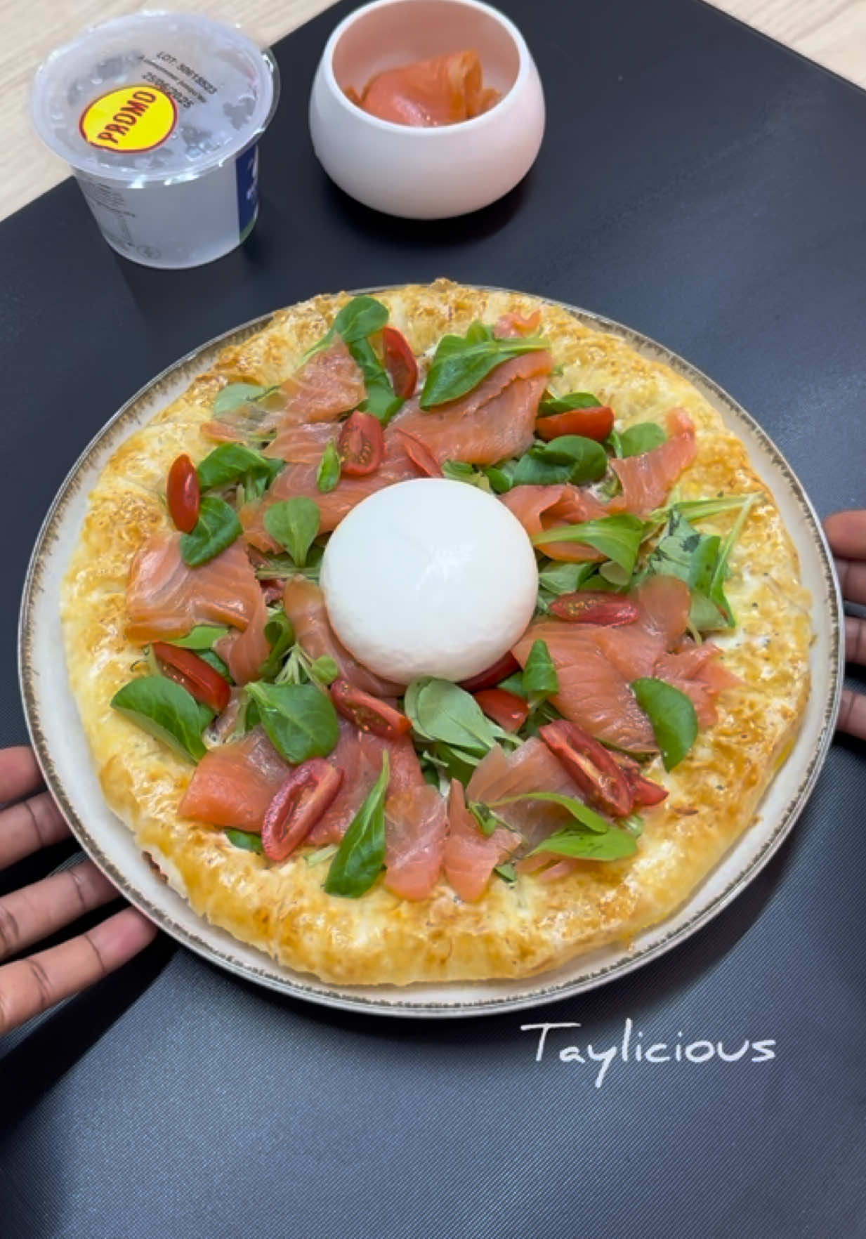A post by @tay_liicious on TikTok caption: Tarte gourmande Fourrée au Fromage, Saumon Fumé et Burrata 🧀  Ingrédients : 1 pâte feuilletée Mozzarella râpée 🧀 1 jaune d’œuf + un peu de lait (pour la dorure) Fromage à tartiner (type Boursin) 🥚 🥛  Mâche 🥗  Tomates cerises 🍅  Saumon ou truite fumée 🍣 1 burrata Crème de balsamique 1. Déroulez votre pâte feuilletée. Disposez du fromage râpé (mozzarella) tout autour, au niveau des bords. Repliez les rebords de la pâte sur le fromage pour former une croûte garnie. Scellez bien à l’aide d’une fourchette 2. Badigeonnez les bords avec un mélange de jaune d’œuf et de lait pour une belle dorure. Piquez la pâte avec une fourchette pour éviter qu’elle ne gonfle à la cuisson     3. Enfournez à 180°C pendant environ 15 minutes, jusqu’à ce que la pâte soit bien dorée     4. Une fois la pâte refroidie, tartinez le fond avec un fromage à tartiner (j’ai utilisé du Boursin)     5. Ajoutez ensuite de la mâche, des tomates cerises coupées en deux, puis des tranches de saumon ou truite fumée     6. Déposez une burrata au centre. Arrosez le tout de crème balsamique épaisse et c’est prêt 😍 #recette #burrata #saumonfume #chaleur #ete #salade #patefeuilletee #recettefacile #recetterapide #tayliicious 