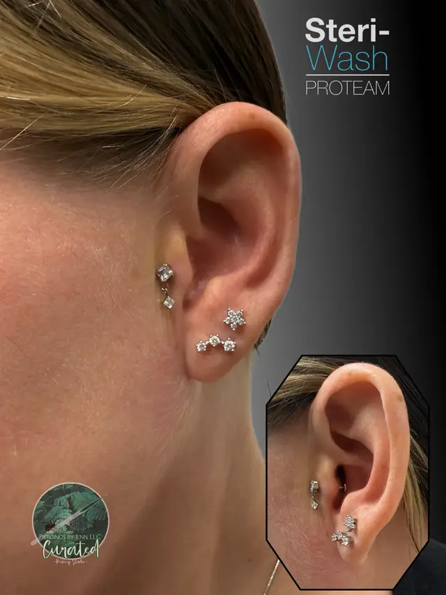 A post by @piercingsbyjenn on TikTok caption: This beautiful client came in and we did a radiant dangle piece for her tragus She decided on this beautiful ASTM F-136 threadless implant grade titanium 5mm CZ with flower dangle with a 16g 10mm threadless matching post(downsize in 4 weeks approximately) from @HBJUS  💦aftercare from @Steri-Wash PAC #steriwashproteam #steriwash 💦 📆book today for your next stabbing…. www.piercingsbyjenn.com @SolaTemeculaMurrieta  #piercingshop #piercings #piercing #piercingsoftiktok #pierced #fyp #fypage #piercingstudio #safepiercing #bodypiercer #bodypiercerlife #professionalpiercer #fypシ #curatedear #tragus 