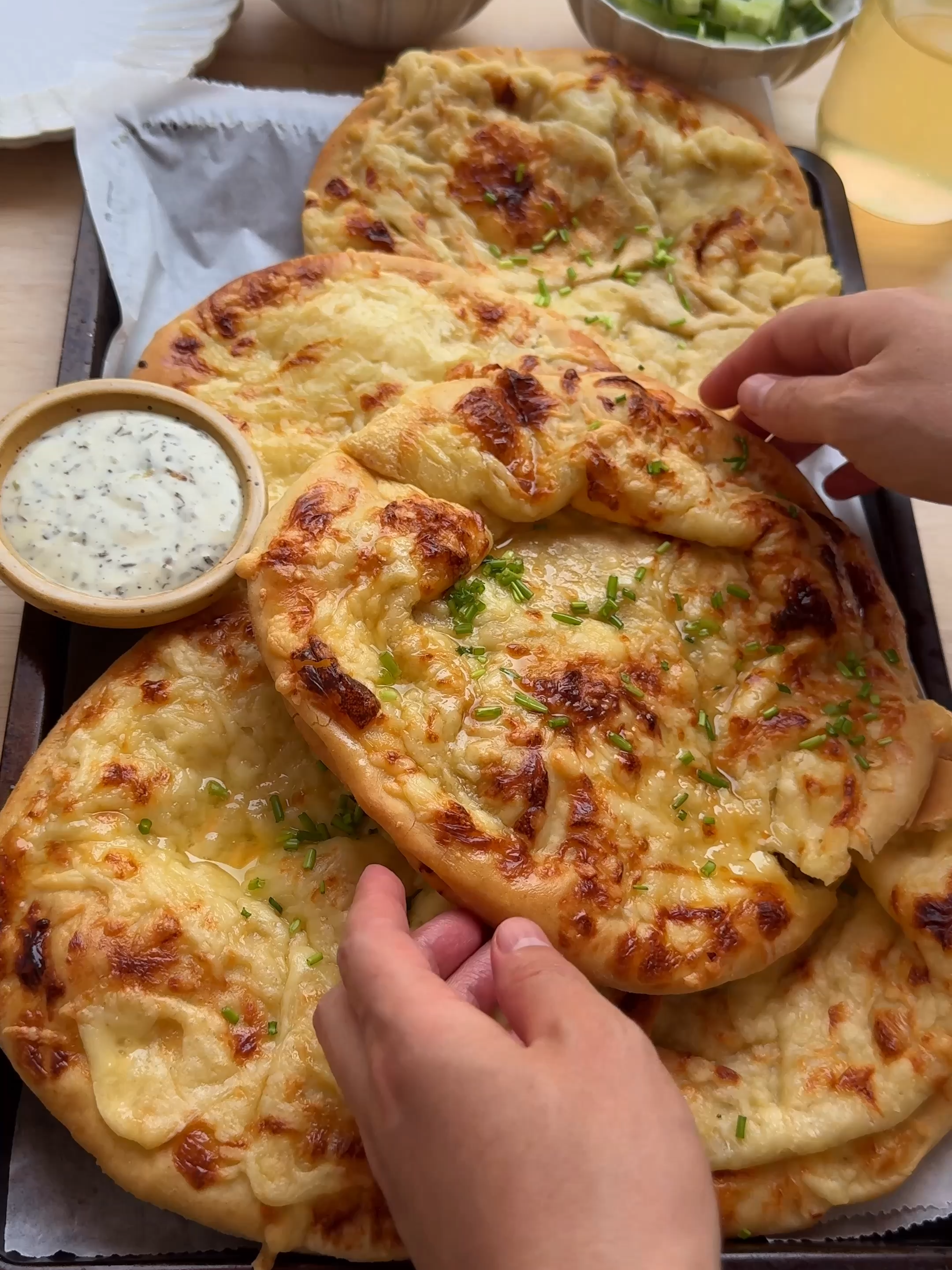 A post by @kookmutsjes on TikTok caption: BREAD WITH BEEF AND CHEESE #food #recipe #foryou #pizza #bread #cheese #beef #fyp DOUGH 250 ml lukewarm water 8 g instant yeast 12 g honey 35 ml sunflower oil 400 g flour (all-purpose flour) 50 g fine semolina 8 g salt (1⅓ teaspoons) BEEF MIXTURE 400 ground beef 4 g salt (⅔ teaspoon) 3 g ground cumin (1 teaspoon) 2 g garlic powder (⅔ teaspoon) 3 g ras el hanout (1 teaspoon) 2 g black pepper (⅔ teaspoon) 2 g cayenne pepper (⅔ teaspoon) 10 g fresh parsley 100 g yellow onion (1 yellow onion) 50 g tomato (half a tomato) 30 ml olive oil TOPPING cheese spread slices of cheese grated cheese Place the lukewarm water, yeast, and honey in a deep bowl. Mix well and let it rest for 5 minutes. Add the sunflower oil and briefly mix. Then add the flour, fine semolina, and salt. Knead for 10–12 minutes until smooth. Cover and let the dough rise for 1 hour, or until it has doubled in size. For the beef mixture, combine the ground beef with salt, cumin, garlic powder, ras el hanout, black pepper, cayenne powder, chopped parsley, onion, tomato, and olive oil. Set aside. Deflate the dough and divide it into 12 equal pieces of about 60 grams each. Shape each piece into a ball. Roll each ball into a flat circle. Repeat with the remaining dough balls. Place a slice of cheese on half of the dough circles, leaving the edges free. Spoon a portion of the beef mixture over the cheese and spread a bit of cheese spread on top. Cover with a second dough circle and press the edges down firmly to seal the filling inside. Place the filled buns on a baking tray lined with parchment paper. Spread a layer of cream cheese on top and sprinkle with grated cheese. Let the dough rise again for 30 minutes. Bake in a preheated oven for 15–20 minutes at 200°C (400°F). I place them a little lower in the oven so the bottoms bake nicely as well.