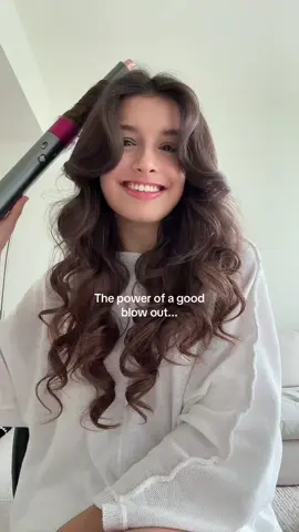 A post by @anastasiagerrans on TikTok caption: *just styled it. #blowout #dysonairwrap #curledhair 