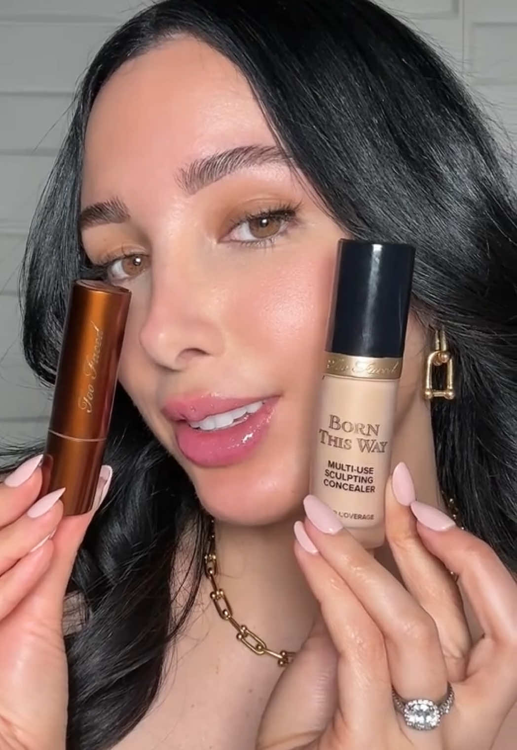 A post by @toofaced on TikTok caption: two products @Mar can't live without?! 🤭 Our Born This Way Super Coverage Concealer and Chocolate Soleil Melting Bronzing and Sculpting Sticks! 🍫💖 She tops off her look with our Cloud Crush Blush, Kissing Juicy Tint shade Bubblegum, and Kissing Jelly Lip Oil Gloss shade Birthday Kiss! ✨ Shop all of these products now on toofaced.com! #toofaced #tfcrueltyfree 