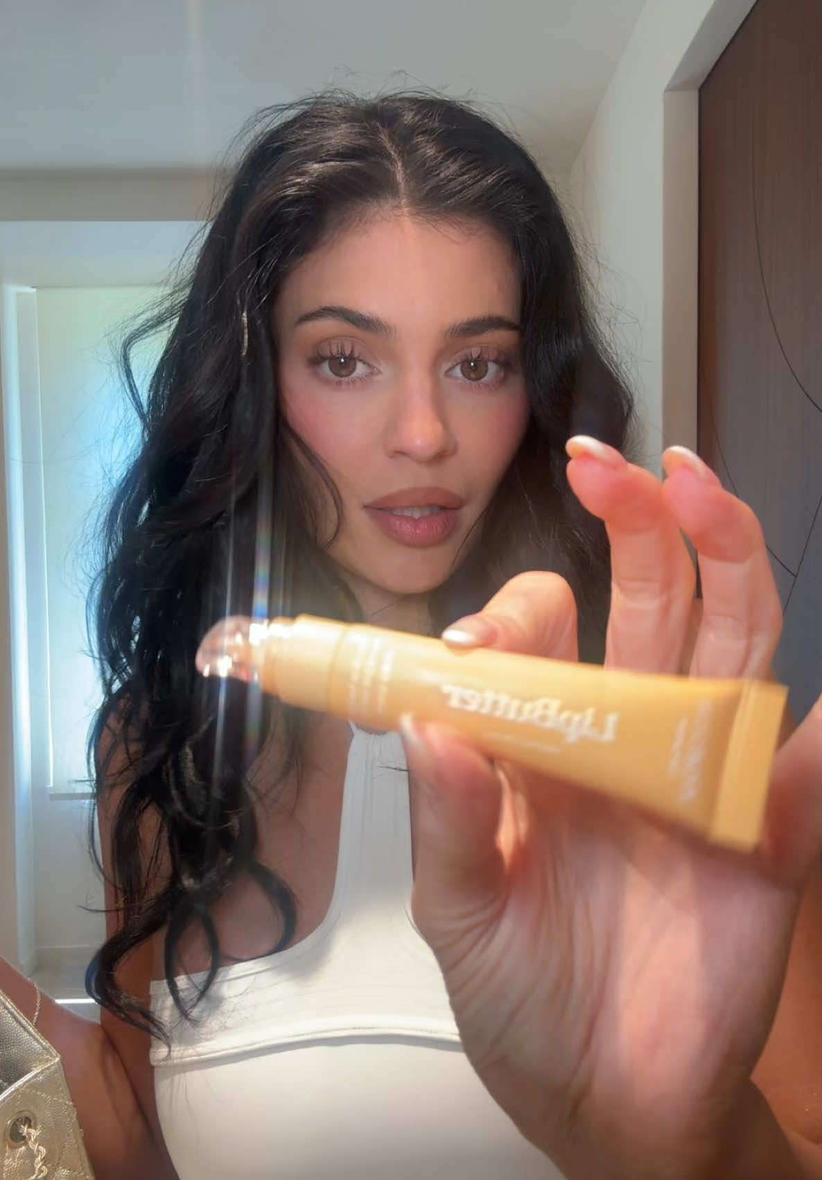 A post by @kyliejenner on TikTok caption: GRWM saint tropez 🤍 my new peach mango lip butter launches JULY 9 <33 