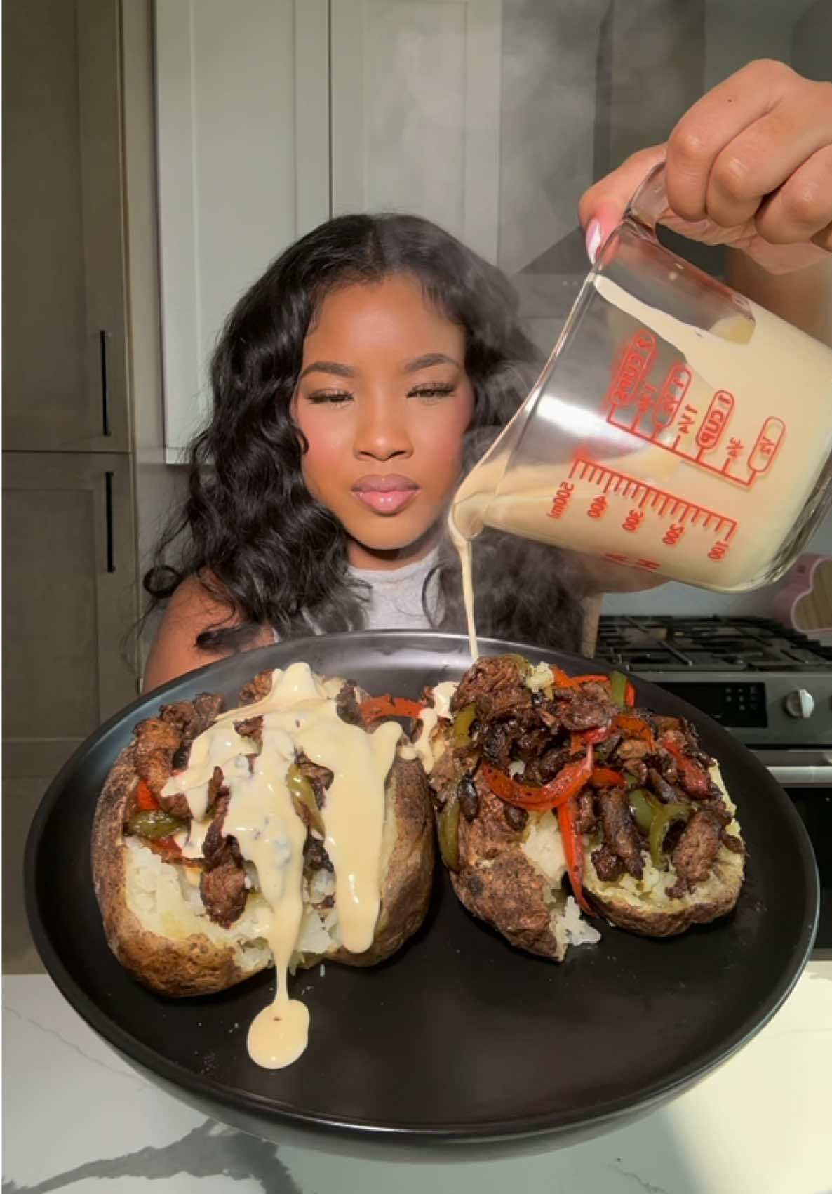 A post by @cookingwithdestiny_ on TikTok caption: Philly cheesesteak loaded baked potatoes 🥔 