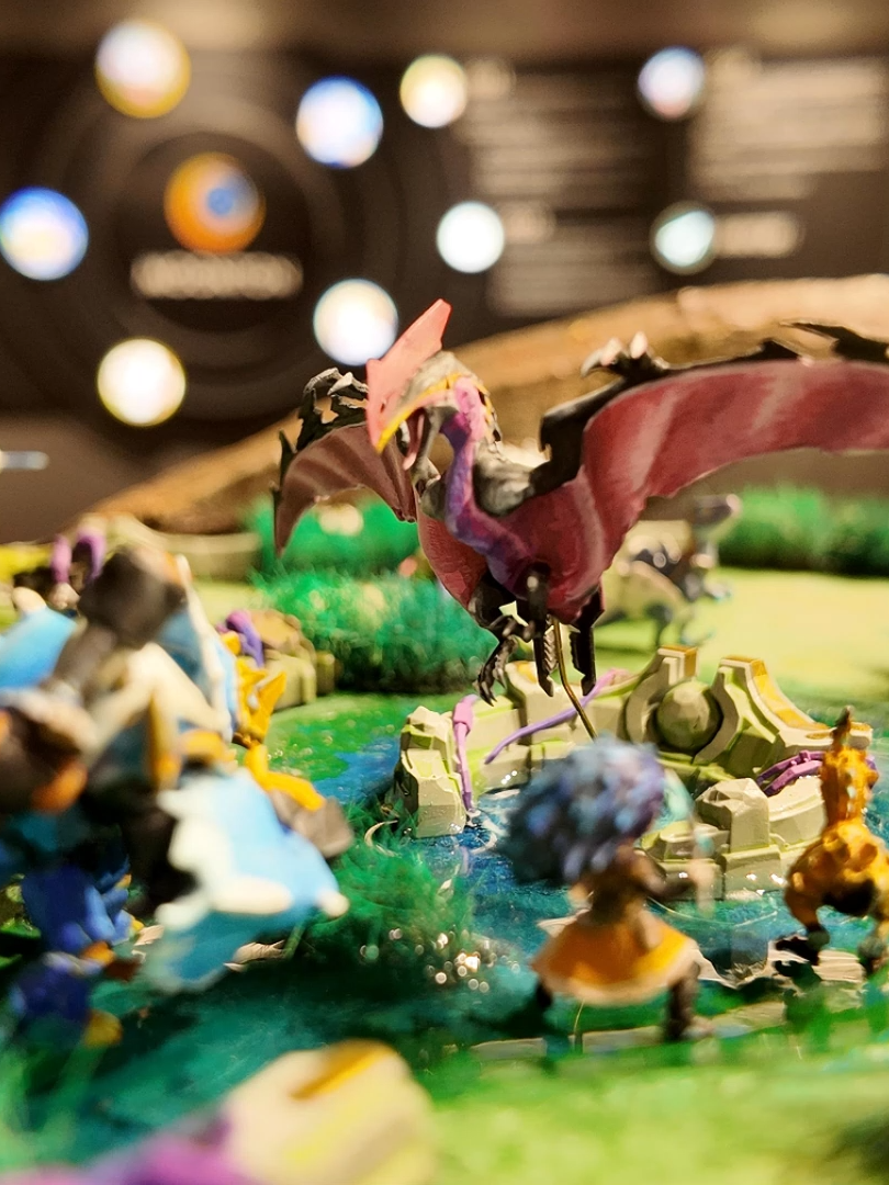 A post by @mlbbttofficial on TikTok caption: 70 days of handcrafting went into creating the realistic ALLSTAR map "Dino Planet", featuring Roar, Smolderhorn, Vibrolasher... and exotic flora like man-eating plants... How do you rate this scene recreation? #DIYCrafting #MiniatureScenes #Diorama #MLBBAllStar #MLBBDINOPLANET #MobileLegendsBangBang