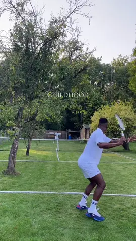A post by @olympics on TikTok caption: Grass-court tennis in your own back garden... unbeatable! Even with a few trees in the way 🌳🎾 📹: @maxencebertimon  #Olympics #Sports #Tennis