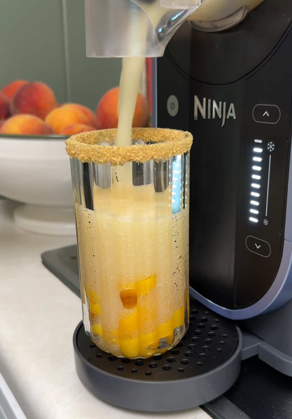 A post by @joshandmomma on TikTok caption: Wait yall….did momma really just invent the Slushi of the Summer 😳#NinjaPartnerHer peach cobbler slushi is 100% a must try!! And our Ninja SLUSHi made it so easy. 🙈 #joshandmomma #joshsmom #ninjaslushi @Ninja Kitchen 
