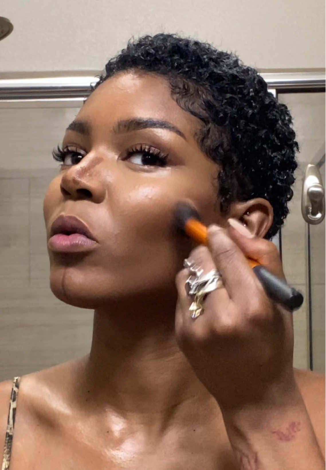 A post by @nymcfly on TikTok caption: A face. Jewelry + hair linked in bio ofc✨ #shorthairstyles #pixiecut #basemakeup #blackgirlmakeup 