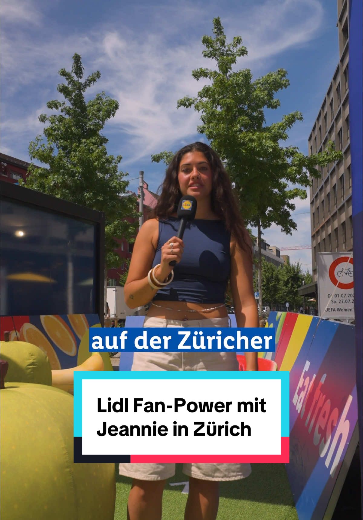 A post by @ on TikTok caption: Die Vorrunde ist fast vorbei, aber @Jeannie ist nicht zu bremsen! 😎 In Zürichs Fan Zone sorgt sie beim Lidl Stand für Chaos mit Charme und ganz viel Fußballliebe 💥 Heute steht das letzte Spiel für das deutsche Team an. Gegner? Schweden 🇸🇪. Für welches Team seid ihr? 🔥  #WEURO2025 #neverstopgrowing #onyourteam #FemaleFootball #UEFA #lidlde #lidllohntsich