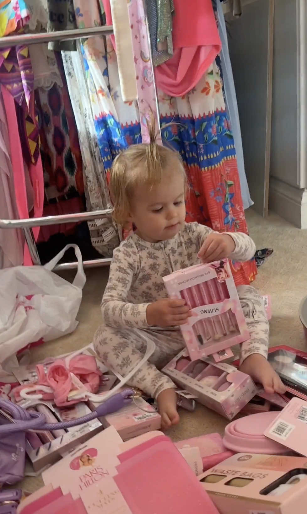 A post by @parishilton on TikTok caption: Welcome to the Sliving Home Shopping Network 🛍️✨ Today’s episode: a @Ross Dress for Less haul featuring my makeup, cookware and pet lines, and starring the two most adorable shopping assistants, Phoenix and London 🩷🥰 #SlivingMom #RossHaul 