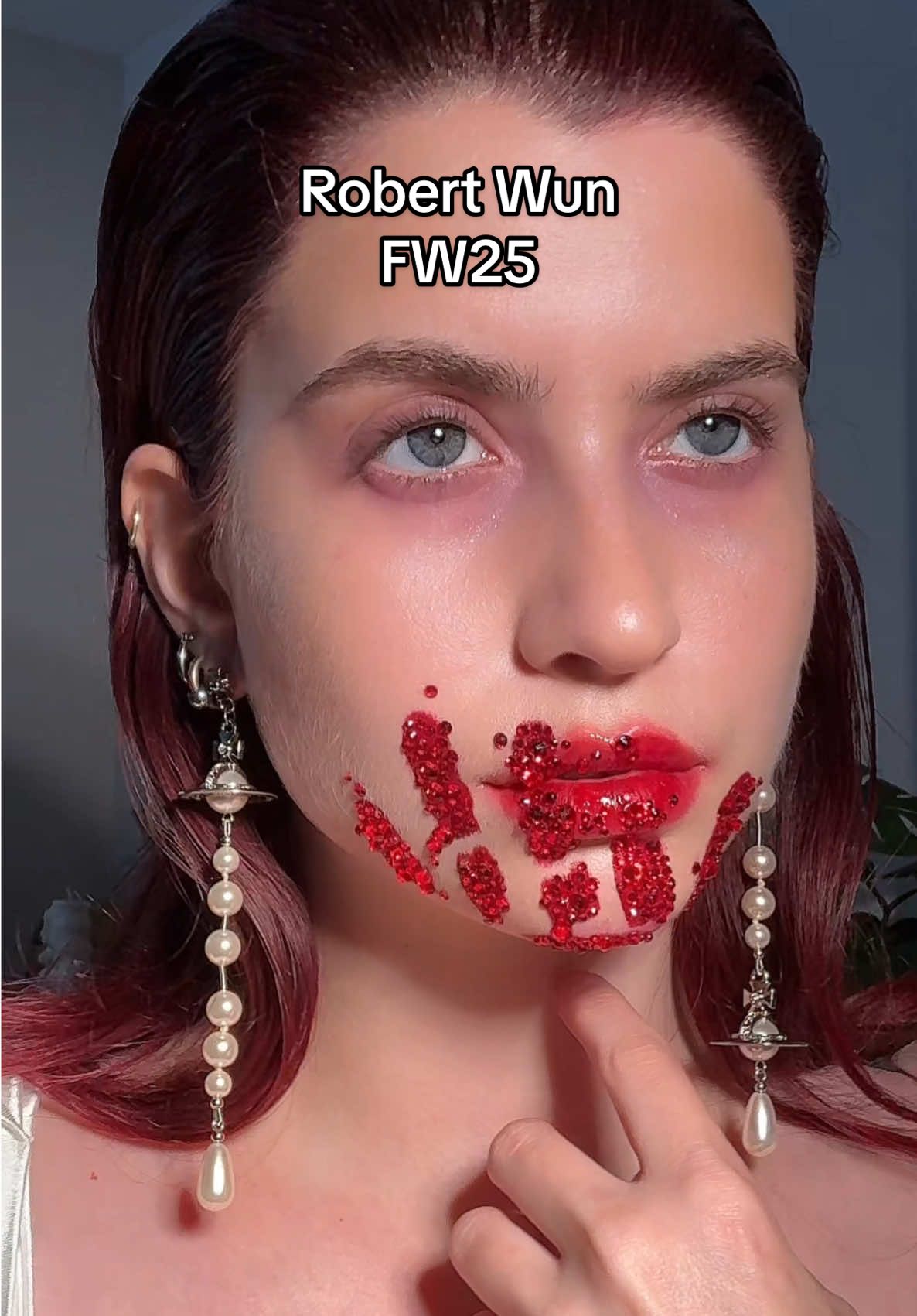 A post by @abbyroberts on TikTok caption: robert wun FW25 💋🩸 forever inspired by @robertwun ‘s insane couture, and stunning makeup by @valentina1121li  products used: @VIOLETTE FR petal bouche @Charlotte Tilbury digital lilac palette, HFF crystals from amazon @Pat McGrath Labs glass skin spray #runway #makeup #fashion #robertwun