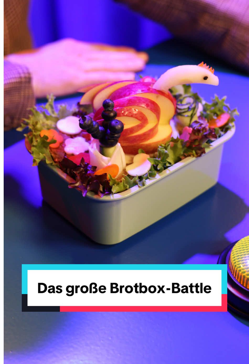 A post by @ on TikTok caption: Bereit für das große Brotbox-Battle!? 🚨 Welches Käsebrot wird gewinnen, welches wird verschmäht? 🧀🥪🥖🍎🥦 Kommen euch diese Situationen bekannt vor? Aber keine Sorge, liebe Eltern, Martin weiß ganz bestimmt, was wirklich wichtig ist. #lidllohntsich #lohntsich #brotboxbattle