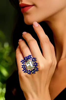 A post by @erikschaix on TikTok caption: Bague centrée d’un diamant fancy yellow coussin de 2,5 carats, entouré de fleurs émaillées bleu cobalt rehaussées de pistils sertis de diamants blancs. L’émail translucide donne un éclat profond aux pétales, évoquant une couronne de myosotis stylisés autour de la pierre centrale. L’ensemble est monté sur or blanc, alliant délicatesse artisanale et éclat précieux.#paris #unique #jewelry #shopping #workshop 