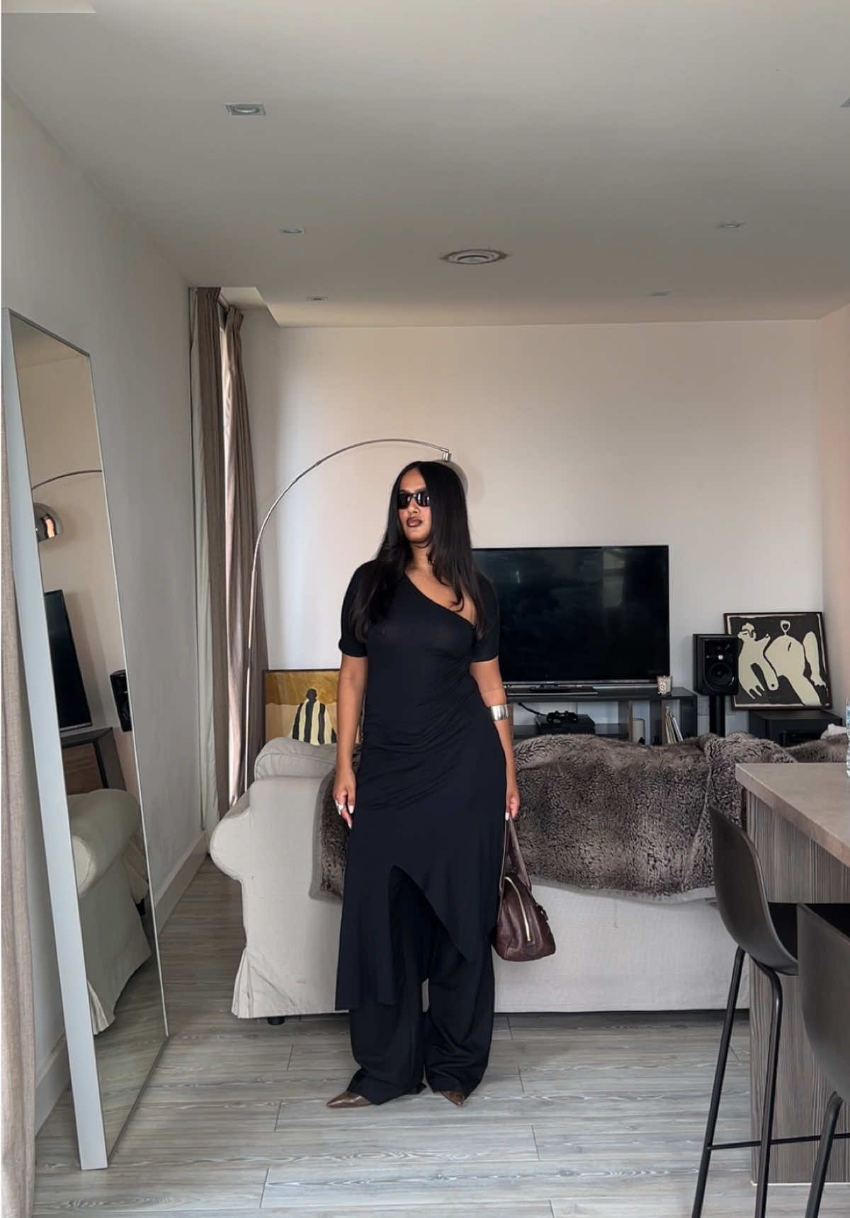 A post by @davinakareer on TikTok caption: dress over pants combo is lethal x #gimaguas #dressoverjeans #vintagegucci #bottega #jpg #OOTD #outfitoftheday #outfitinspo #allblackoutfit #guccibag #blackdress @SSENSE 