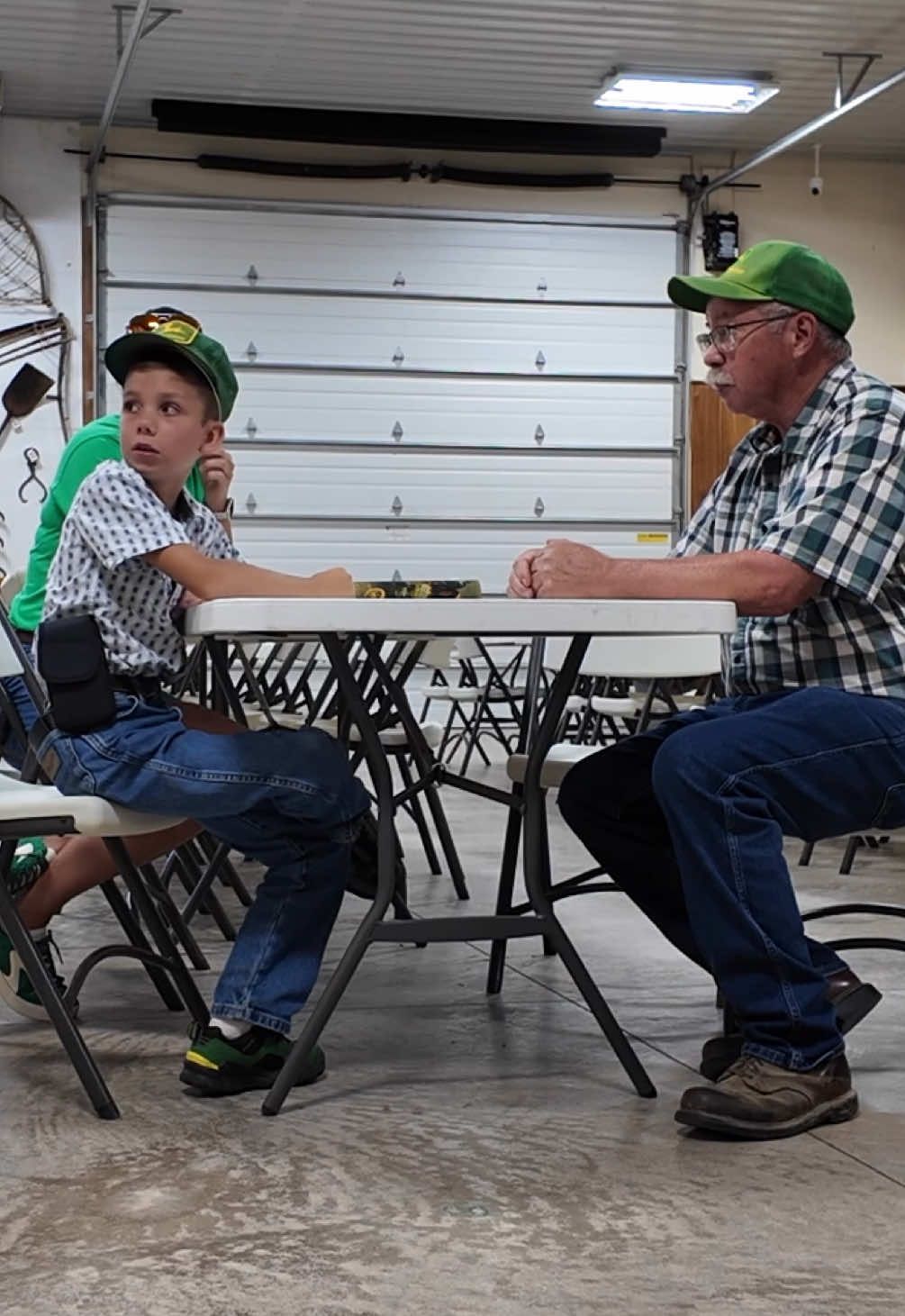 A post by @justajacksonthing on TikTok caption: The past week at the Whitley County 4-H fair they have an Ag museum that has been there for 40 years. Jackson enjoyed talking with all the different farmers that hang out there and going through some interesting books they have. ##justajacksonthing##farm##tractors##farmlife##fyp##farmtok##fair##johndeere##skecherspartner