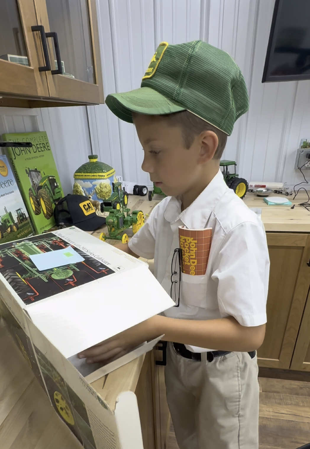 A post by @justajacksonthing on TikTok caption: Jackson is on the hunt for a real @John Deere A but now he will enjoy the 1/16th scale one he bought from a local auction #tractorkid #makefarmingfun #justajacksonthing #farm #farmtok 