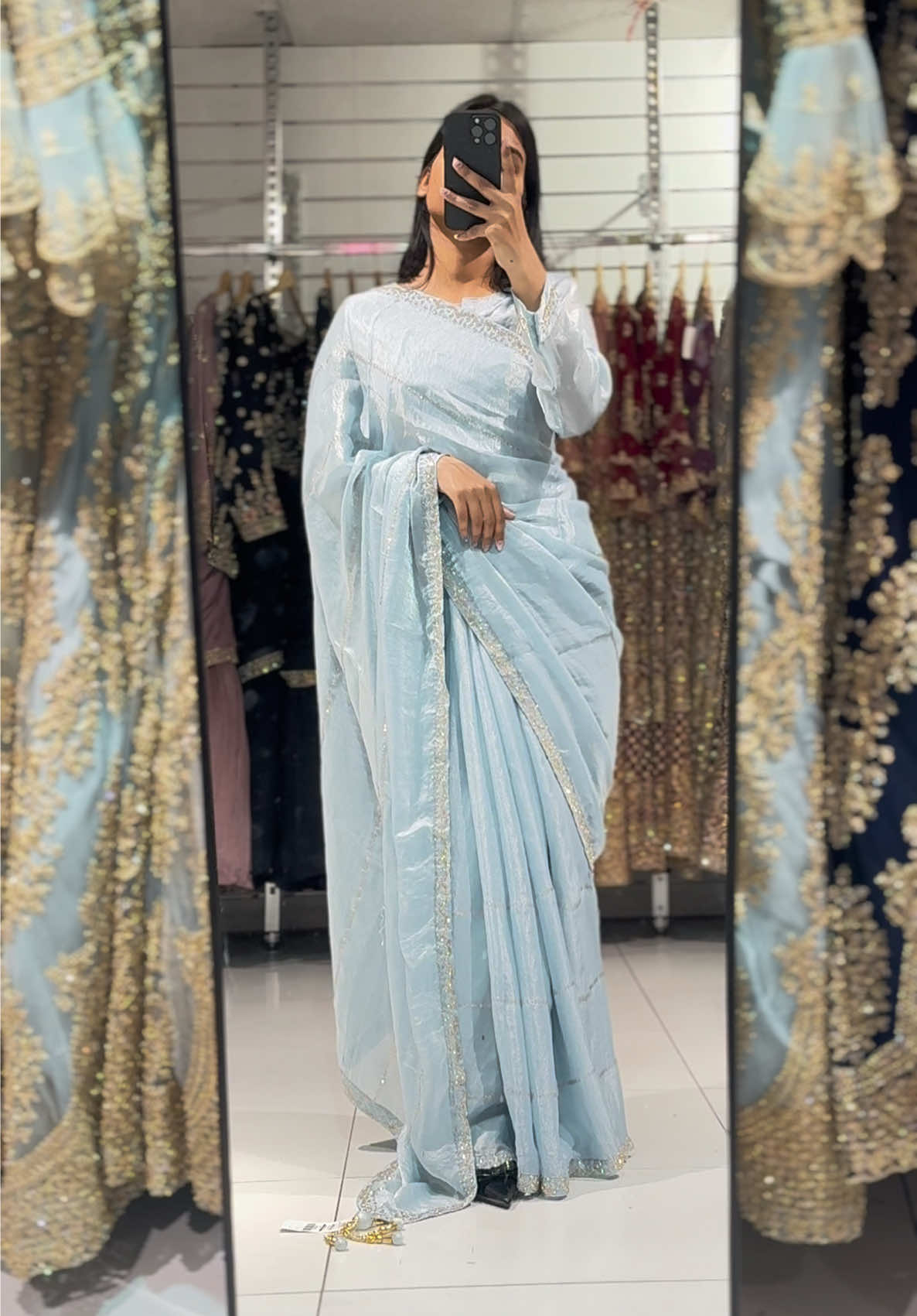 A post by @fabeha_sarees on TikTok caption: FBSR-652 Designer Saree with Delicate Golden Detailing Drape yourself in understated elegance with this rich look designer saree, featuring delicate golden thread detailing and a subtly shimmering fabric finish. The minimalistic striped embroidery gives it a graceful flow, while the intricately bordered pallu and hem add a touch of finesse. Perfectly paired with a matching stitched blouse, this saree is your go-to for graceful festivities and sophisticated gatherings. #partywearsaree #tiktokmademebuyit #fyp #fabehafashions #foryou 