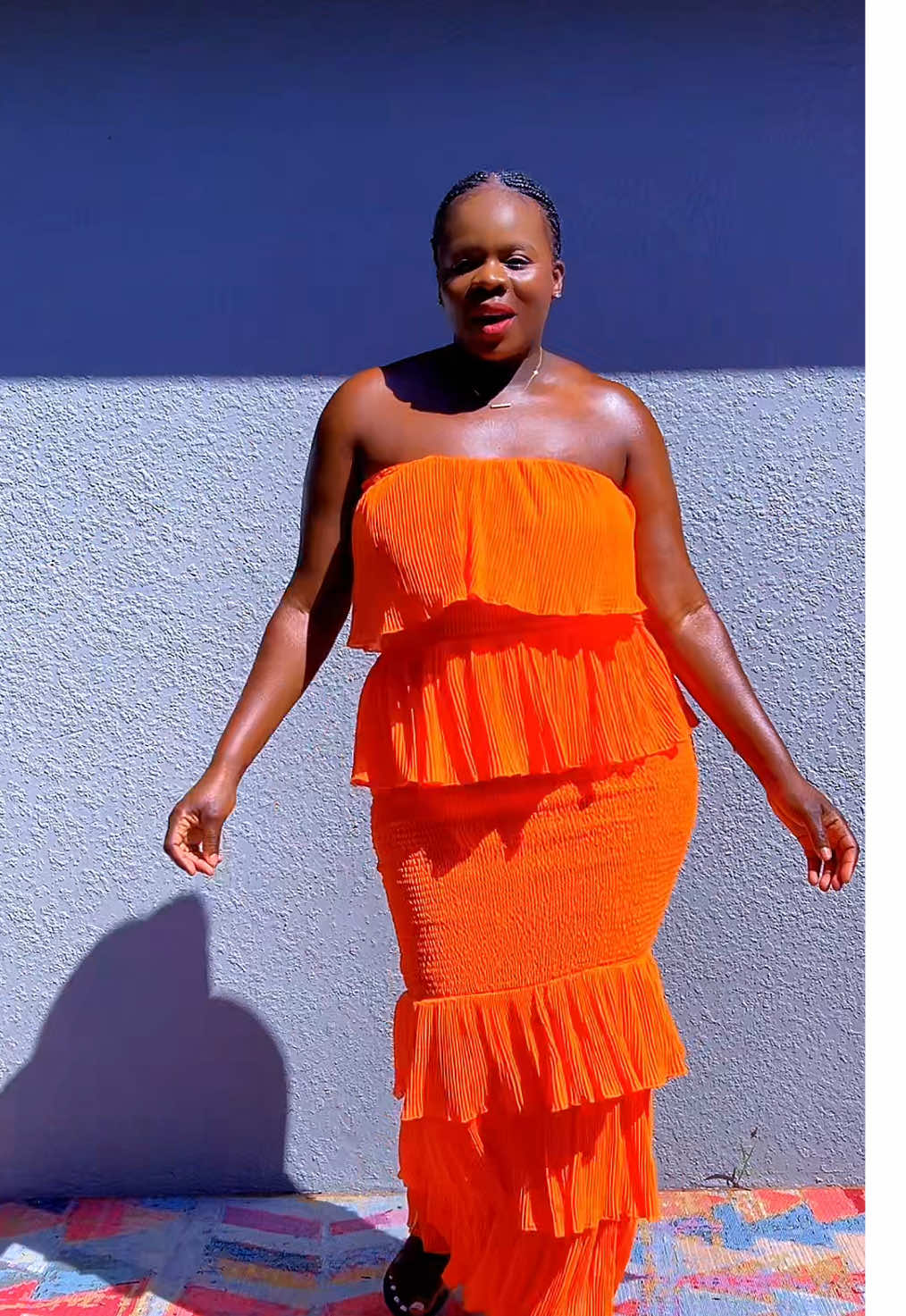 A post by @auntiebougie on TikTok caption: Serving bold energy in this sunset-orange ruffle maxi dress ☀️✨ Perfect for vacation vibes, brunch slay, or date night glow. Comfortable, flattering, and unapologetically vibrant.  #OrangeDressMagic #MaxiDressGoals #SummerStyle #BoldAndBeautiful #BlackGirlStyl